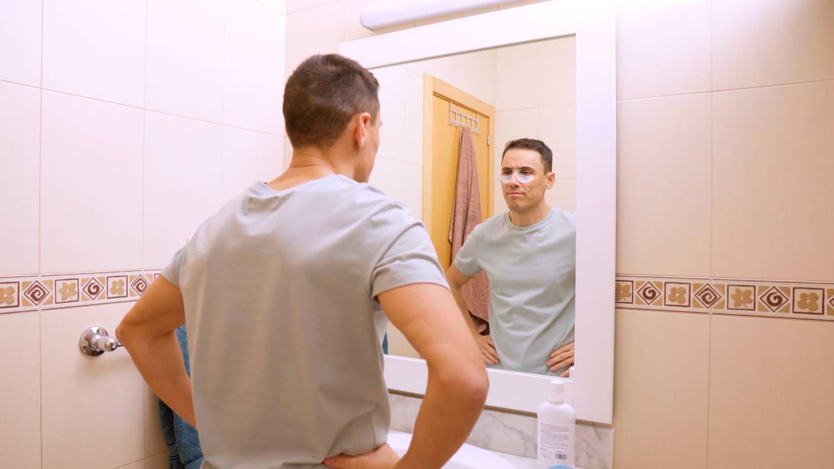 Man applying under eye patches for dark circles